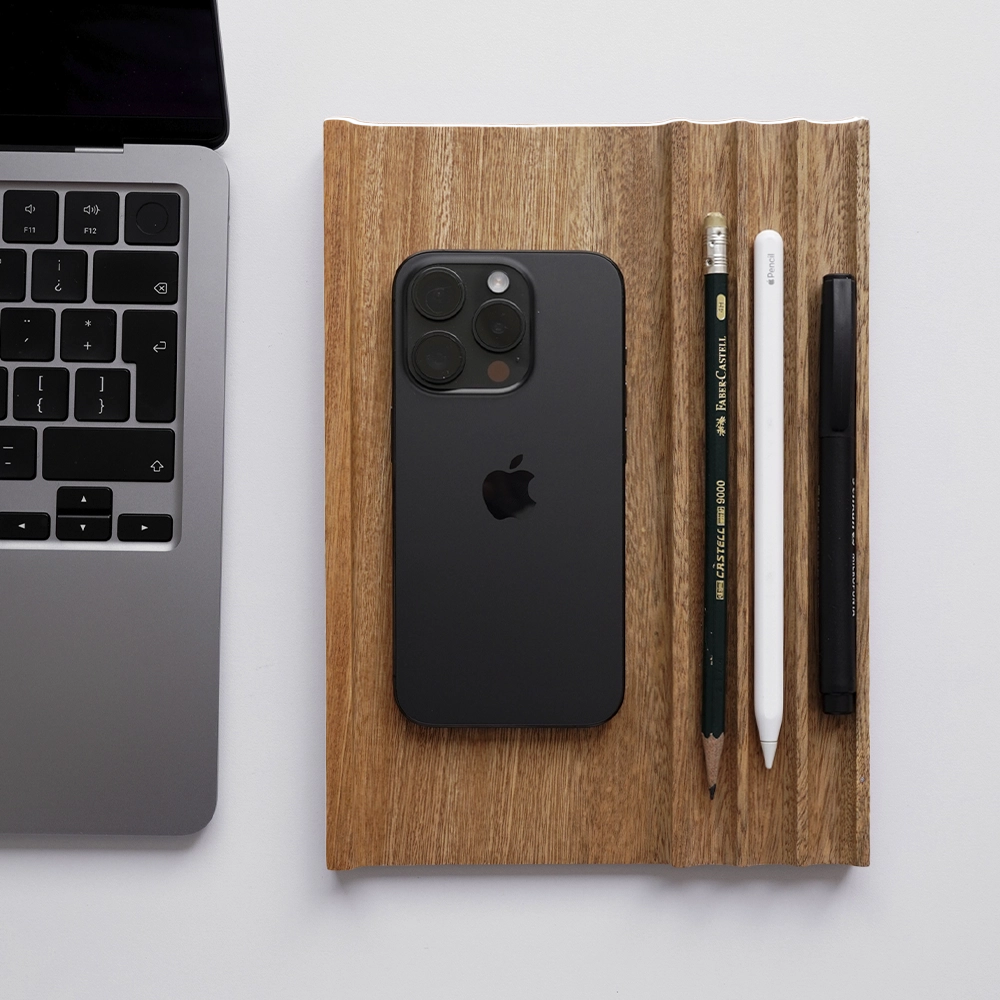 Valet Tray con celular y lápices junto a un portátil
